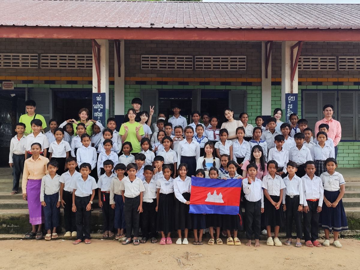 カンボジアの小学校で子どもたちと記念撮影するツアー参加者